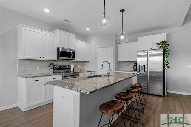 kitchen featuring stainless steel appliances, a sink, baseboards, dark wood finished floors, and recessed lighting