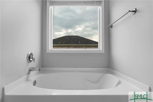 bathroom with a garden tub and healthy amount of natural light