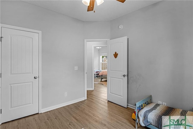 unfurnished bedroom featuring light wood-style flooring, baseboards, and ceiling fan