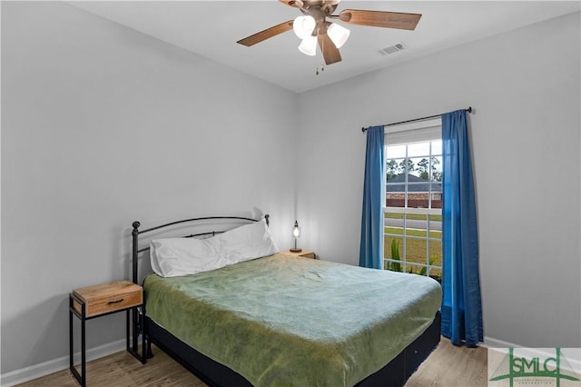 bedroom with wood finished floors, baseboards, and a ceiling fan