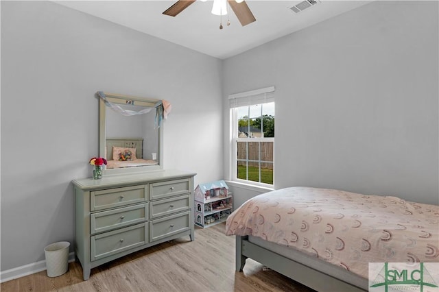 bedroom featuring light wood-style floors, a ceiling fan, and baseboards