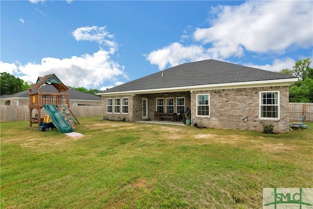 rear view of property with a playground, a patio area, and brick siding