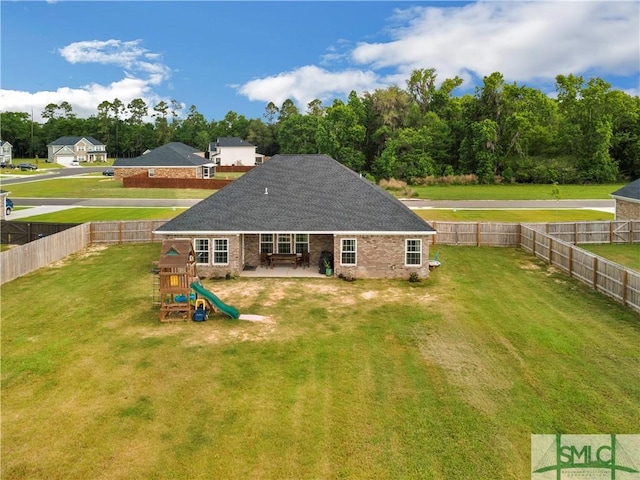 back of property featuring brick siding, a playground, a patio, and roof with shingles