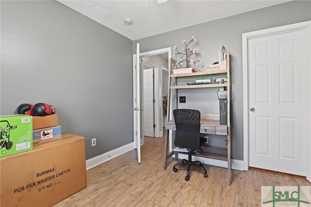 office area with light wood finished floors and baseboards