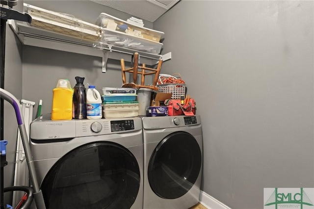 laundry room with washing machine and dryer and baseboards