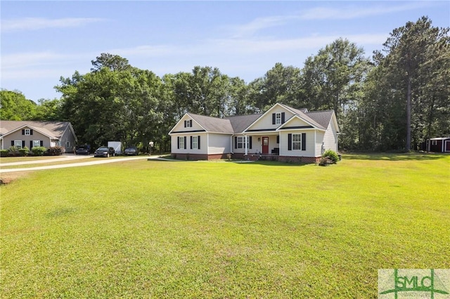 view of front of house with covered porch, a front lawn, and view of wooded area