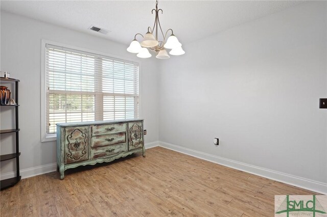 2431 Walden Way, Statesboro, GA 30458 - empty room with a chandelier, light wood-type flooring, plenty of natural light, and baseboards