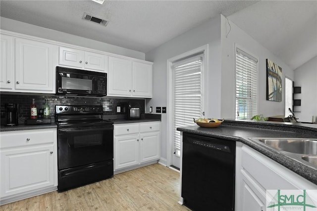 kitchen featuring black appliances, light wood-style floors, dark countertops, tasteful backsplash, and white cabinetry