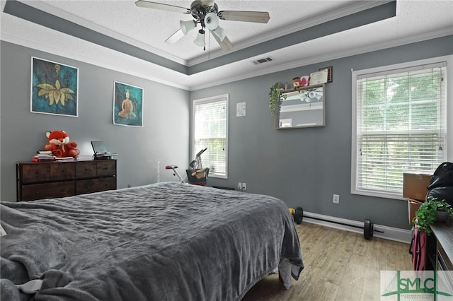 bedroom featuring a raised ceiling, crown molding, light wood-style flooring, baseboards, and a ceiling fan