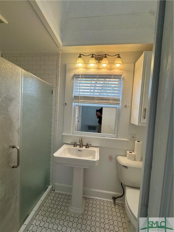 1305 E Anderson St, Savannah, GA 31404 - full bathroom featuring a stall shower, toilet, baseboards, and tile patterned floors