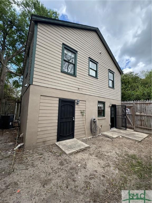 1305 E Anderson St, Savannah, GA 31404 - back of house featuring a gate, fence, central AC, and stucco siding