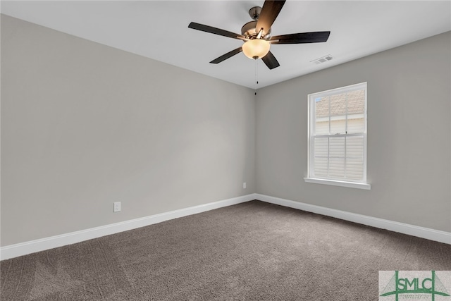 spare room with dark carpet, a ceiling fan, and baseboards