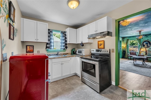 239 Chatham Ave, Pooler, GA 31322 - kitchen featuring under cabinet range hood, stainless steel range with electric stovetop, white microwave, a sink, and white cabinets