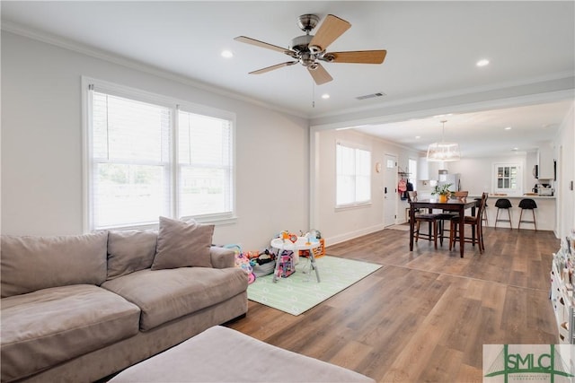 living area featuring ornamental molding, wood finished floors, ceiling fan, recessed lighting, and baseboards