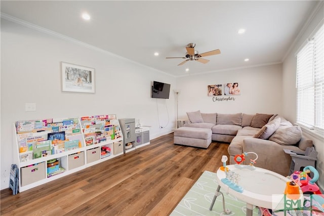 living area featuring wood finished floors, a ceiling fan, recessed lighting, crown molding, and baseboards