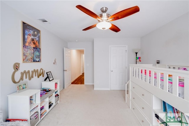 bedroom featuring light carpet, a ceiling fan, and baseboards