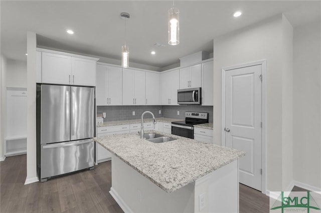 124 Benelli Dr, Pooler, GA 31322 - kitchen featuring appliances with stainless steel finishes, a sink, white cabinets, dark wood-type flooring, and a kitchen island with sink