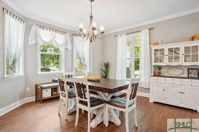 186 Goodman Dr, Midway, GA 31320 - dining space with a chandelier, crown molding, wood finished floors, plenty of natural light, and baseboards