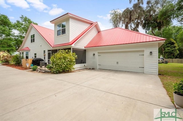 186 Goodman Dr, Midway, GA 31320 - traditional-style home with metal roof, driveway, and an attached garage