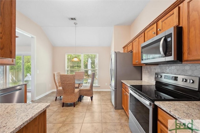 81 Parker Ln, Richmond Hill, GA 31324 - kitchen featuring stainless steel appliances, brown cabinetry, baseboards, decorative light fixtures, and light stone counters