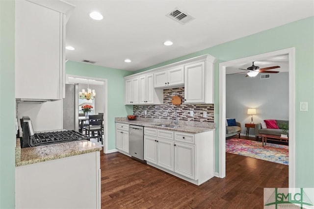 kitchen with a sink, dishwasher, dark wood-type flooring, white cabinetry, and tasteful backsplash