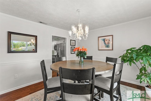dining space with wood finished floors, a chandelier, ornamental molding, and baseboards