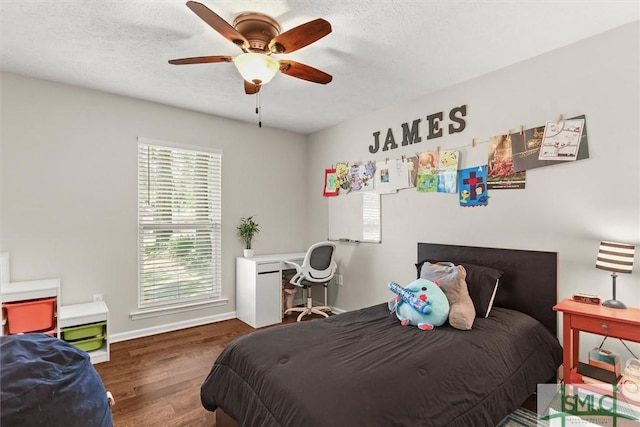 bedroom with wood finished floors, baseboards, ceiling fan, and a textured ceiling