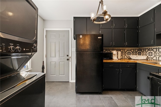 21 Berkley Pl, Savannah, GA 31405 - kitchen featuring black appliances, stacked washer and clothes dryer, light tile patterned floors, decorative backsplash, and a sink