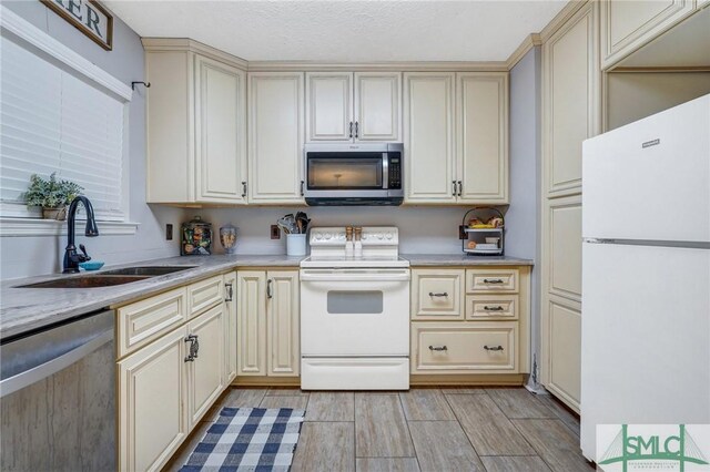 11 Pelican Ct, Richmond Hill, GA 31324 - kitchen with stainless steel appliances, cream cabinets, a sink, and light countertops