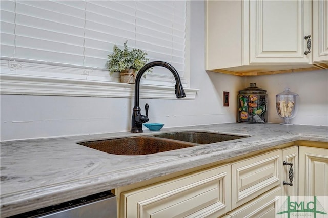 11 Pelican Ct, Richmond Hill, GA 31324 - kitchen view of a sink, dishwasher, light stone counters, and cream cabinetry
