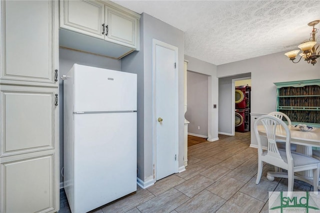 11 Pelican Ct, Richmond Hill, GA 31324 - kitchen featuring freestanding refrigerator, a chandelier, estacked washer and dryer, and baseboards