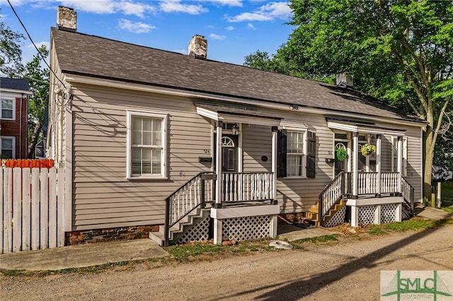 view of front of home featuring a chimney and fence