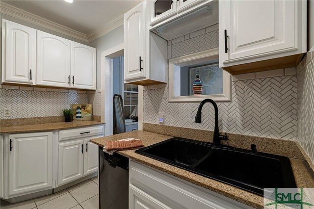 kitchen with a sink, ornamental molding, white cabinetry, decorative backsplash, and light stone counters
