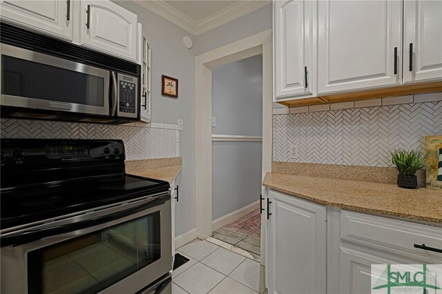 kitchen with range with electric stovetop, stainless steel microwave, crown molding, tasteful backsplash, and white cabinets