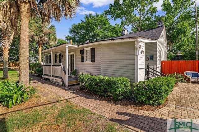 view of front of property featuring fence, a wooden deck, and a patio