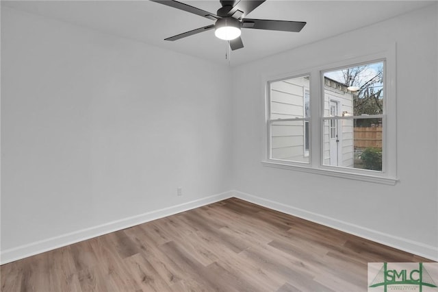 empty room with baseboards, wood finished floors, and a ceiling fan