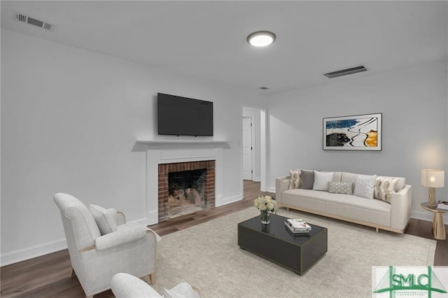 living area with wood finished floors, a fireplace, and baseboards