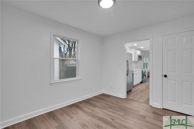 empty room with light wood finished floors and baseboards