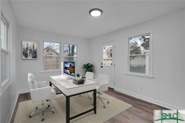 office space featuring healthy amount of natural light, wood finished floors, and baseboards