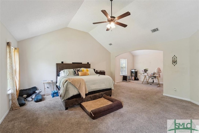 bedroom featuring carpet floors, arched walkways, vaulted ceiling, ceiling fan, and baseboards