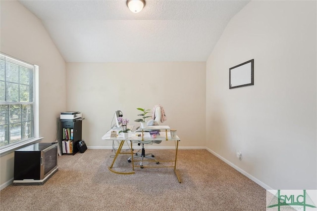 carpeted office featuring lofted ceiling and baseboards