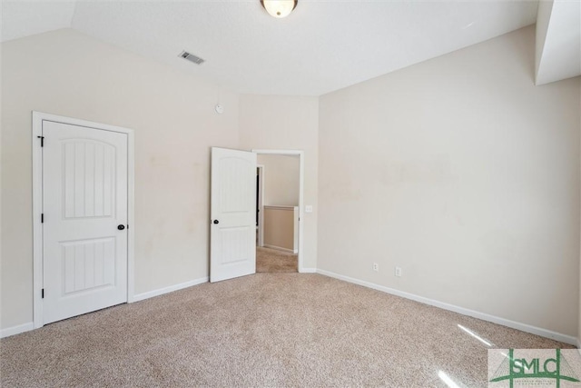 unfurnished bedroom featuring vaulted ceiling, carpet, and baseboards