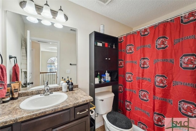 bathroom featuring toilet, vanity, a textured ceiling, and a shower with shower curtain