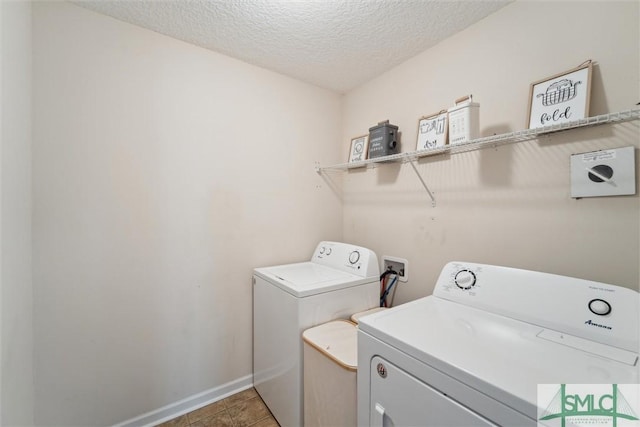 washroom featuring washing machine and clothes dryer, a textured ceiling, baseboards, and light tile patterned floors