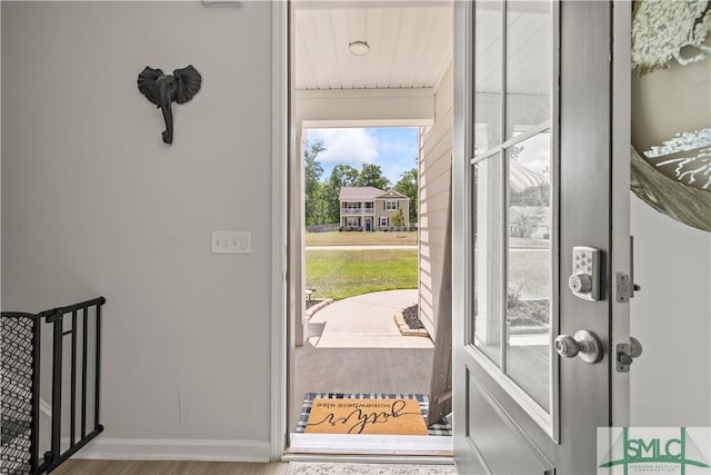 doorway featuring wood finished floors and baseboards