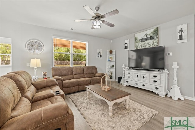 living room featuring a ceiling fan, wood finished floors, healthy amount of natural light, and baseboards