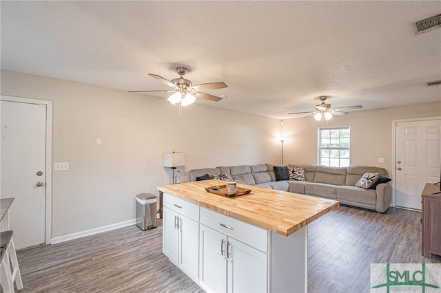 938 Greenbriar Trl, Hinesville, GA 31313 - kitchen with wooden counters, ceiling fan, light wood-type flooring, white cabinetry, and a textured ceiling