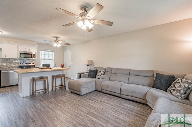 938 Greenbriar Trl, Hinesville, GA 31313 - living room featuring light wood-style flooring, ceiling fan, and baseboards