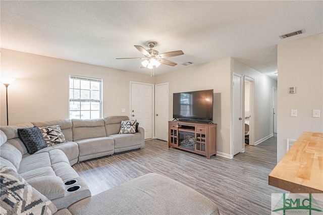 938 Greenbriar Trl, Hinesville, GA 31313 - living room featuring wood finished floors, a ceiling fan, baseboards, and a textured ceiling