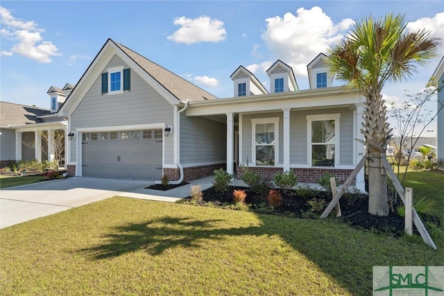 view of front of house featuring brick siding, concrete driveway, a front lawn, covered porch, and a garage